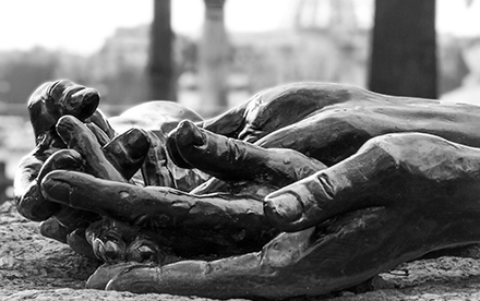 Photo en noir et blanc de Marilg : sculpture de mains dans un jardin parisien.