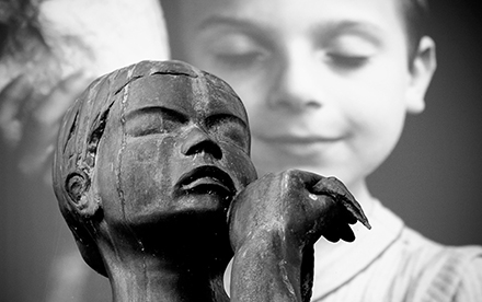 Photo en noir et blanc de Marilg : enfant en photo derrière une sculpture