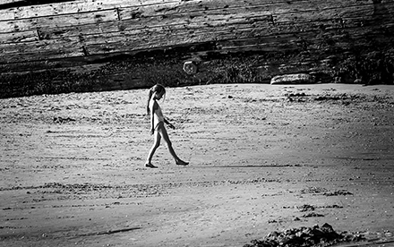 Photo en noir et blanc de Marilg : une petite fille joue sur une plage